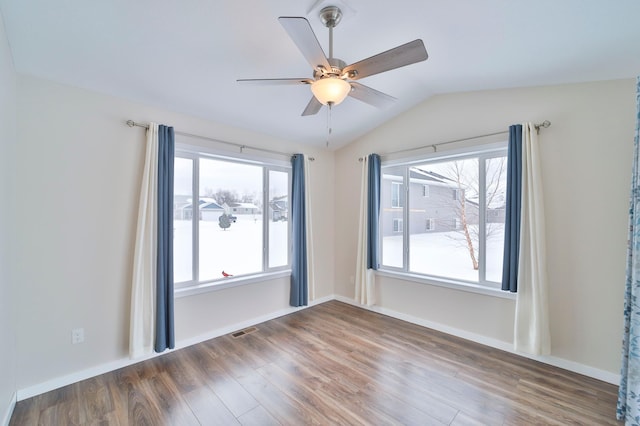 unfurnished room featuring wood finished floors, a ceiling fan, vaulted ceiling, and baseboards