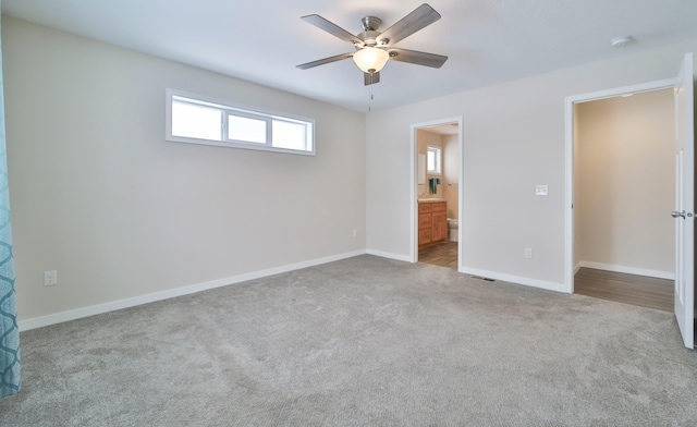 unfurnished bedroom with carpet floors, baseboards, connected bathroom, and ceiling fan