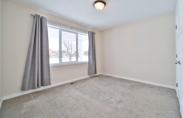 unfurnished room featuring carpet and baseboards