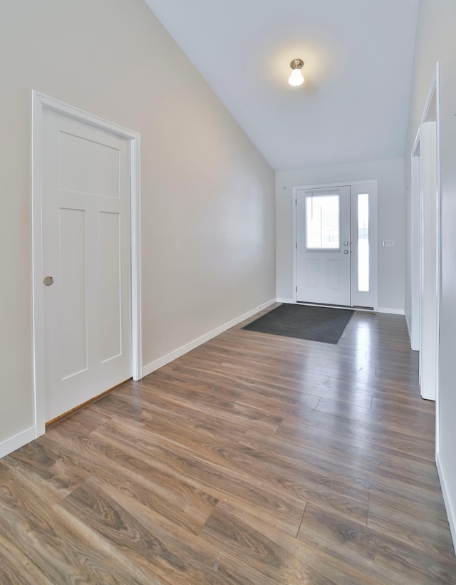 entryway with lofted ceiling, dark wood-type flooring, and baseboards