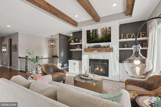 living room with beamed ceiling, wood-type flooring, and built in features