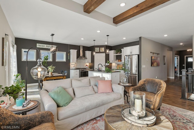 living room with beamed ceiling, sink, an inviting chandelier, and dark hardwood / wood-style flooring