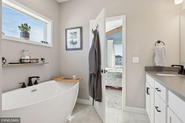 bathroom with tile patterned floors, vanity, and a bathing tub