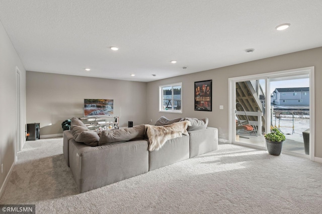 living room featuring light carpet and a textured ceiling