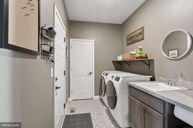 washroom featuring cabinets, sink, and washing machine and clothes dryer