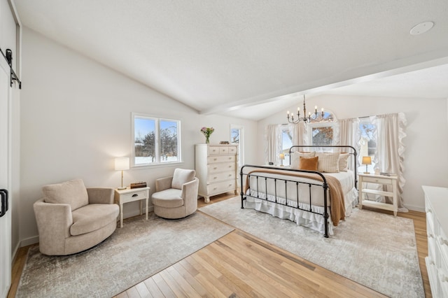 bedroom featuring lofted ceiling, hardwood / wood-style floors, and a chandelier