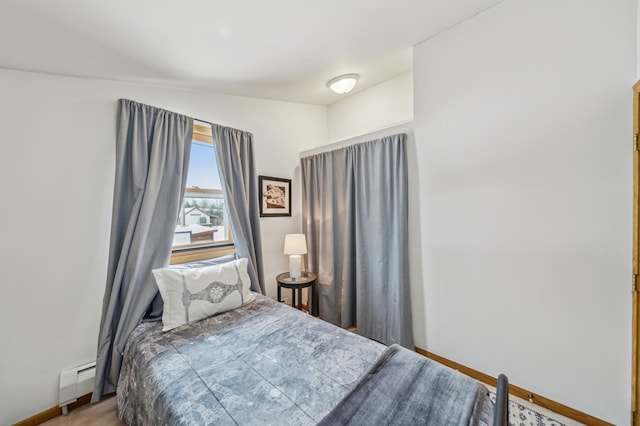 bedroom with carpet flooring and a baseboard heating unit