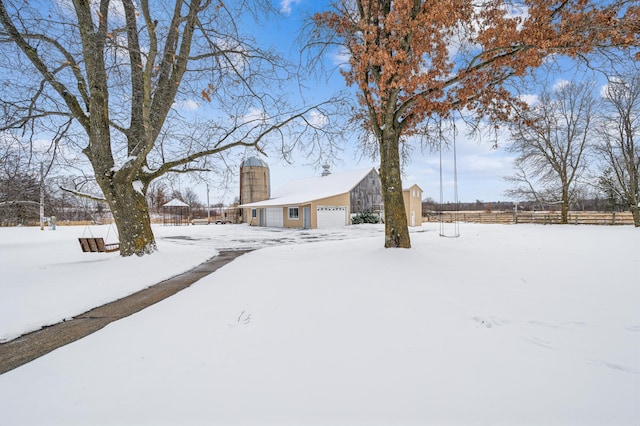 snowy yard with a garage