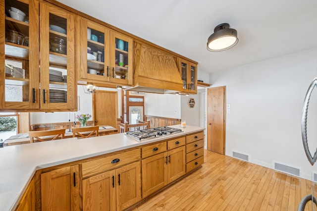 kitchen with light countertops, light wood finished floors, visible vents, and stainless steel gas stovetop