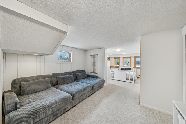 carpeted living area with a textured ceiling and baseboards