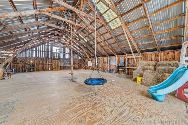 misc room featuring lofted ceiling and metal wall