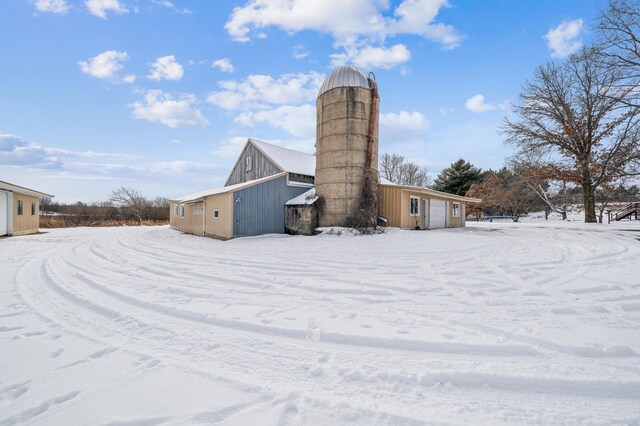 snow covered property with a detached garage