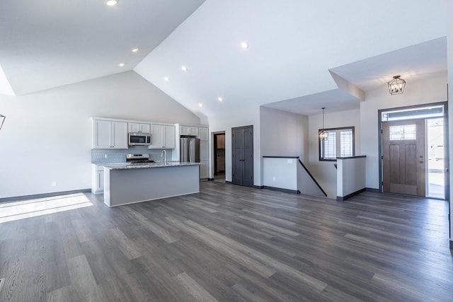 kitchen featuring decorative light fixtures, a chandelier, a center island with sink, stainless steel appliances, and white cabinets