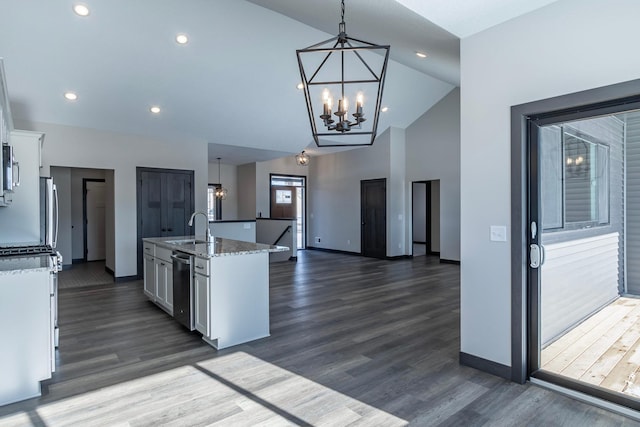 kitchen with pendant lighting, dishwasher, sink, white cabinets, and a kitchen island with sink