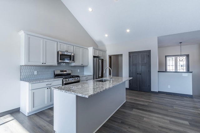 kitchen with white cabinetry, appliances with stainless steel finishes, sink, and a center island with sink