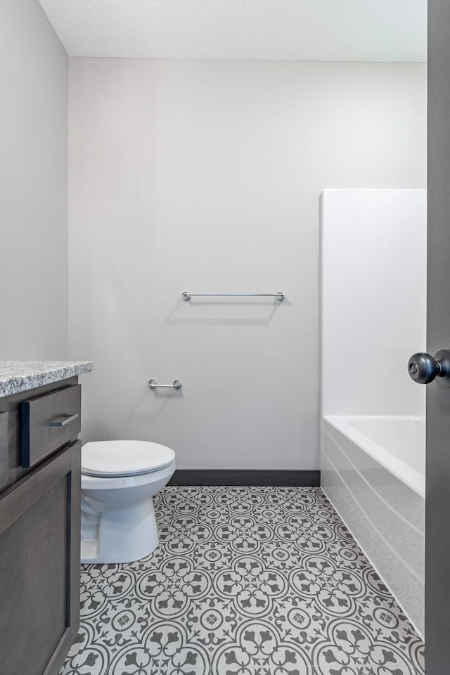 bathroom with vanity, a bath, tile patterned floors, and toilet