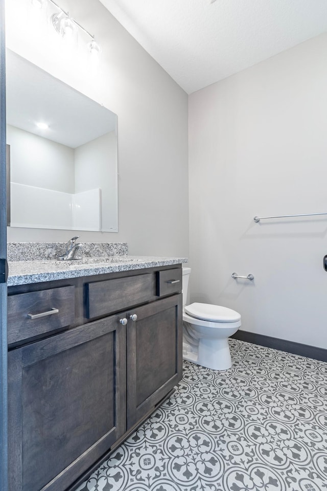 bathroom featuring tile patterned floors, vanity, and toilet