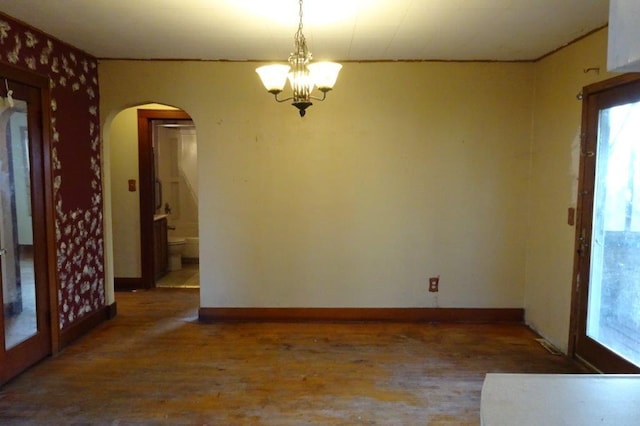 unfurnished dining area with wood-type flooring and a notable chandelier