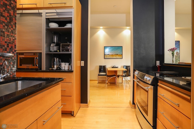 12 Broadway N Unit 206, Fargo, ND 58102 - kitchen featuring stainless steel electric range, light wood finished floors, dark stone counters, and a sink