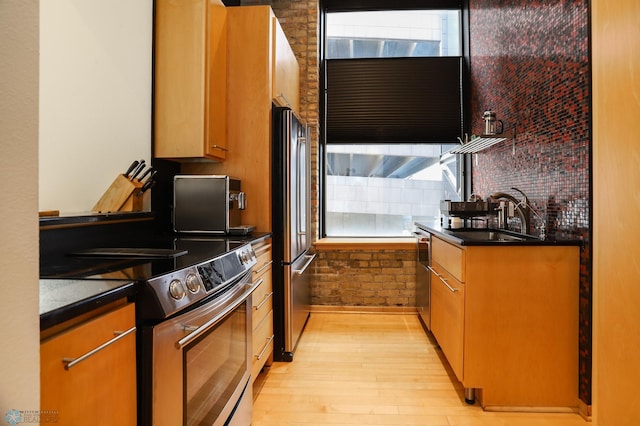 12 Broadway N Unit 206, Fargo, ND 58102 - kitchen featuring appliances with stainless steel finishes, a sink, light wood-type flooring, and dark countertops