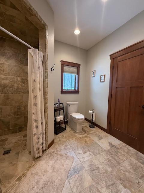 bathroom featuring toilet and a shower with shower curtain