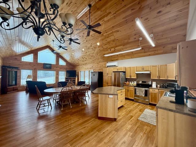 E2614 Bohland Hollow Rd, Wheatland Twp, WI 54624 - kitchen with stainless steel appliances, under cabinet range hood, high vaulted ceiling, a kitchen island, and a chandelier