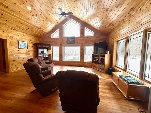 E2614 Bohland Hollow Rd, Wheatland Twp, WI 54624 - living area featuring wood walls, high vaulted ceiling, wood ceiling, ceiling fan, and light wood-style floors