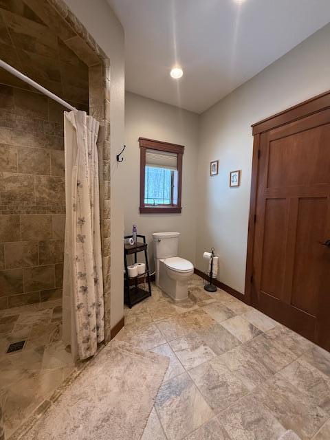 E2614 Bohland Hollow Rd, Wheatland Twp, WI 54624 - bathroom with toilet, a tile shower, and baseboards