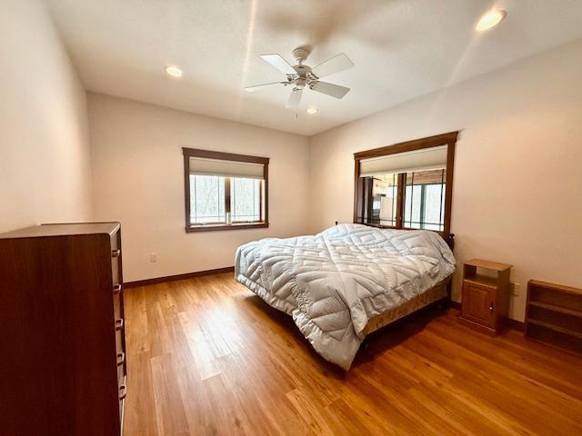 E2614 Bohland Hollow Rd, Wheatland Twp, WI 54624 - bedroom featuring multiple windows, baseboards, wood finished floors, recessed lighting, and ceiling fan