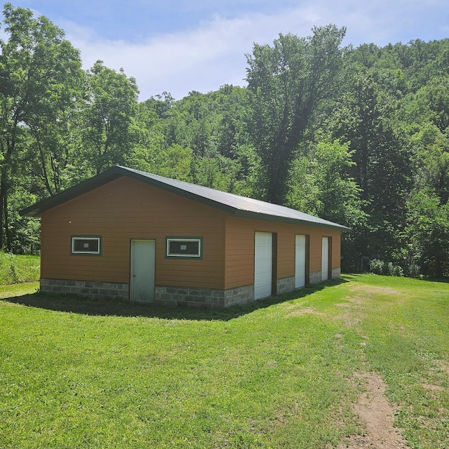 E2614 Bohland Hollow Rd, Wheatland Twp, WI 54624 - view of side of home with a yard, a forest view, and a detached garage