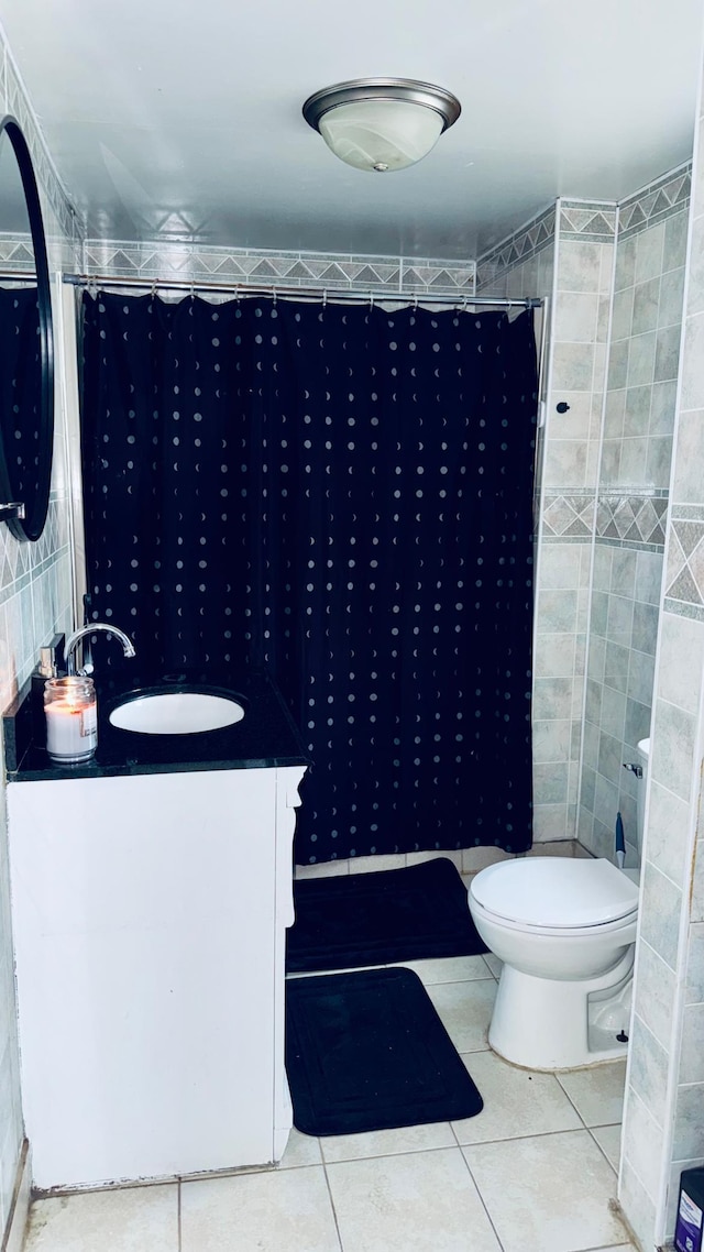 bathroom featuring tile patterned flooring, vanity, curtained shower, and toilet