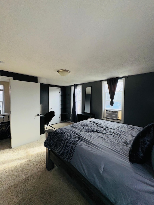 carpeted bedroom featuring cooling unit and a textured ceiling