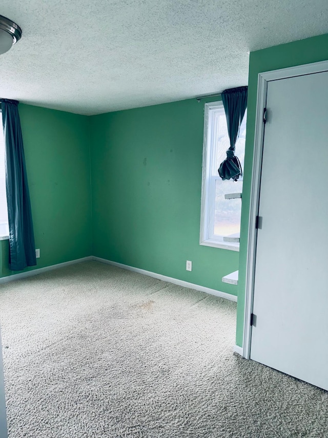 unfurnished room featuring a textured ceiling and carpet