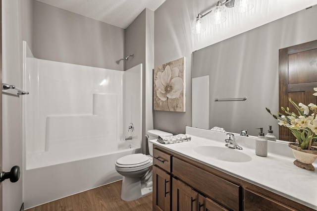 full bathroom featuring wood-type flooring, bathing tub / shower combination, vanity, and toilet