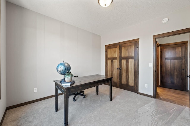 office space with light carpet and a textured ceiling