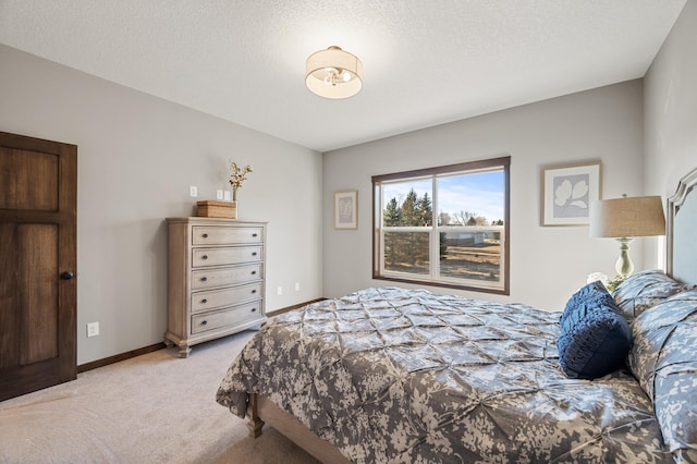 bedroom featuring light colored carpet and a textured ceiling