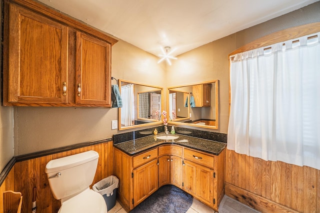 bathroom with wainscoting, vanity, and toilet