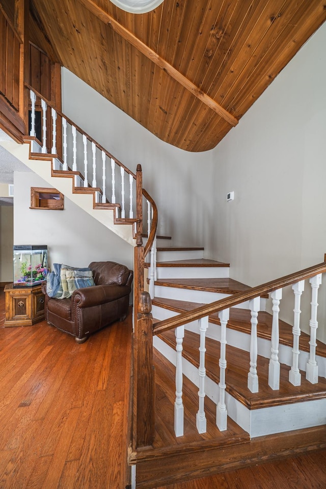 stairway with wood finished floors and wood ceiling