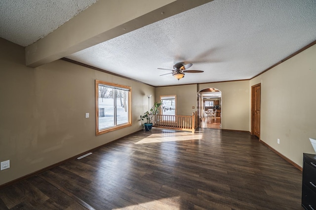 unfurnished living room featuring baseboards, crown molding, arched walkways, and wood finished floors