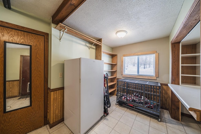 walk in closet featuring light tile patterned floors and beam ceiling