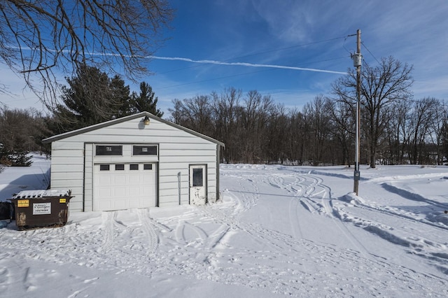 snow covered garage featuring a garage