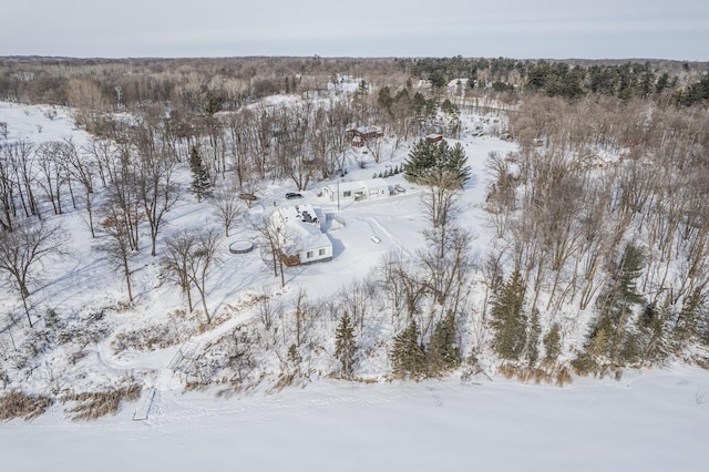 snowy aerial view featuring a wooded view