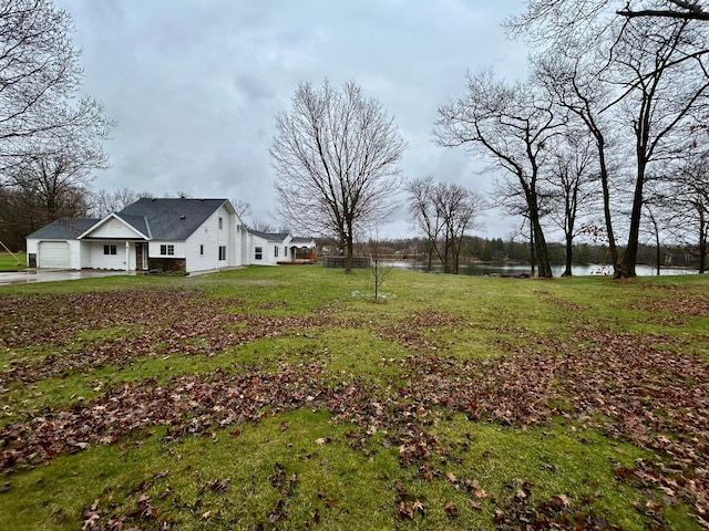 view of yard featuring a water view and a garage