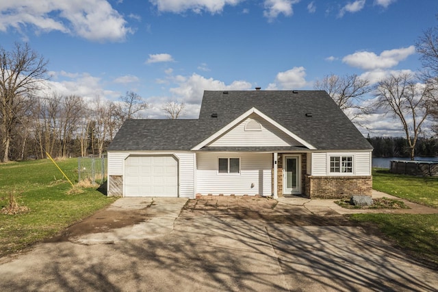 view of front of property with a shingled roof, an attached garage, a front lawn, brick siding, and driveway