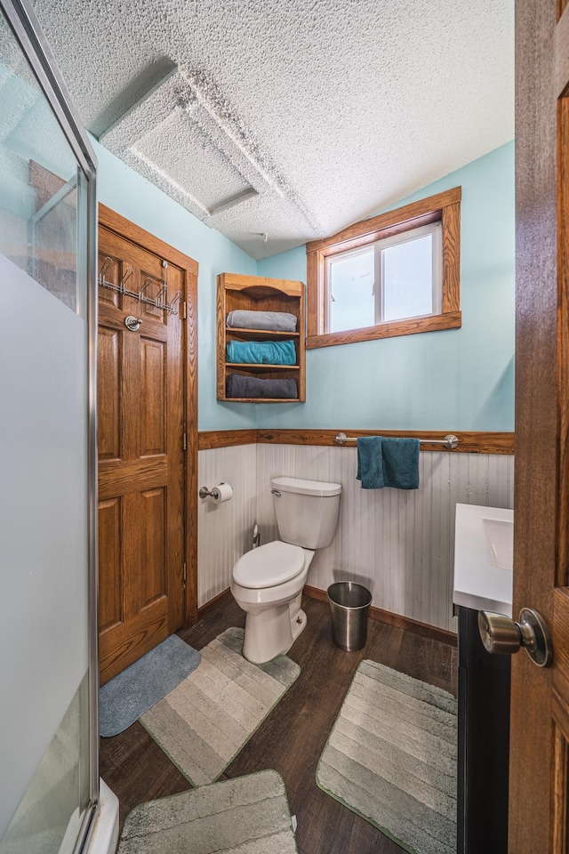 17813 Disse Rd, Erie Twp, MN 56501 - full bath with a shower stall, wood finished floors, wainscoting, toilet, and a textured ceiling