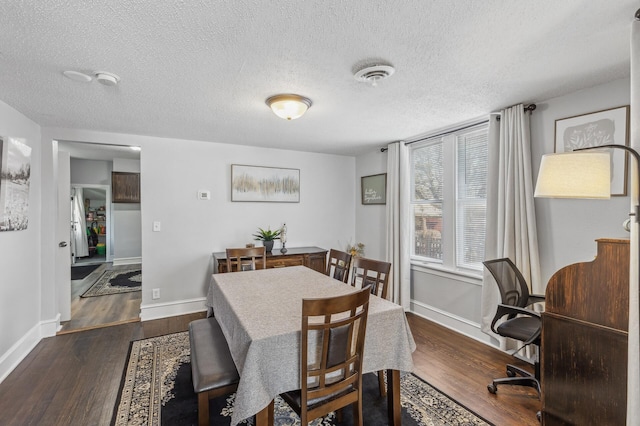 dining room featuring dark hardwood / wood-style floors and a textured ceiling