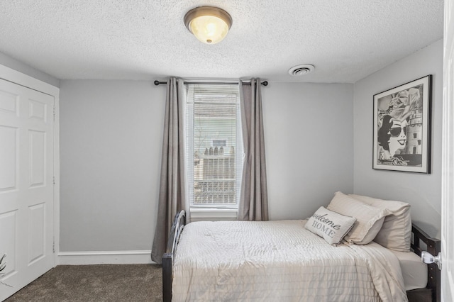 bedroom featuring a textured ceiling and carpet