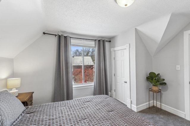 bedroom with vaulted ceiling, a textured ceiling, and carpet