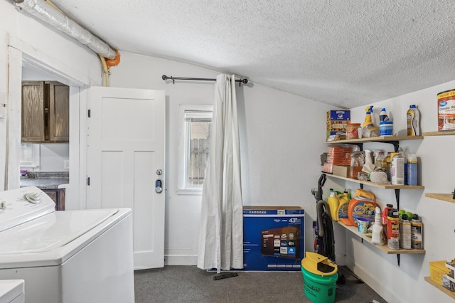 laundry area featuring washing machine and clothes dryer, a textured ceiling, and dark colored carpet