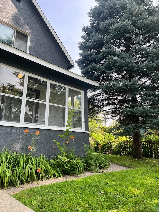 view of side of home with a yard and a sunroom